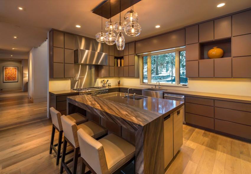A spacious, modern kitchen in a Bethesda home featuring 2025 remodeling trends, including warm oak cabinets, a zoned island layout, and large windows for natural light.